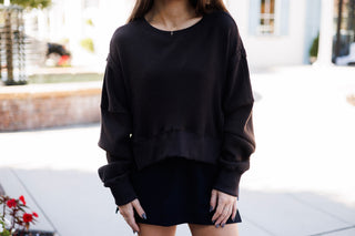 Upper body shot highlighting the rich thermal texture of the dark brown waffle-knit top. Displays the relaxed crew neck, dropped shoulder seams, raw-edge stitched trim, and wide ribbed cuffs and waistband, paired with a subtle gold necklace.