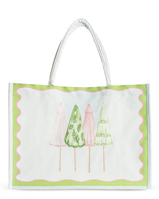 A large white canvas tote bag featuring an artistic illustration of four decorative patio umbrellas in alternating shades of soft pink and leaf green. The umbrellas showcase intricate patterns, including tropical fronds and geometric stripes. The design is framed by a vibrant lime green border with a playful pink scalloped inner edge. The bag is finished with two sturdy white shoulder straps, offering a preppy, coastal-inspired aesthetic perfect for the beach or poolside.
