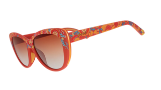 Angled side view of the Goodr Prairie Mystique Garden Party Crasher sunglasses against a transparent background. This perspective highlights the continuous red floral pattern extending down the temple arms, which features the classic "goodr" logo embedded in orange text. The view also reveals a contrasting bright yellow inner frame edge and showcases the curve of the amber gradient lenses.