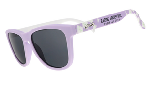 Angled side view of the Goodr Run With Us sunglasses against a transparent background. This perspective highlights the light lavender front frame and solid dark grey lenses, revealing a contrasting solid white inner frame. The temple arms feature a distinctive white and purple argyle diamond pattern with light green accents. The arms showcase the classic "goodr" logo in black and white, followed by bold black text reading "RACING LOUISVILLE FOOTBALL CLUB."