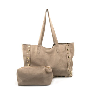 A large, slouchy taupe suede tote bag featuring two long shoulder straps and vertical rows of mixed-size gold stud hardware along the left and right side panels. Displayed on a crisp white background, the tote is paired with a matching smaller taupe suede accessory pouch with a gold top zipper resting in front of it, completing this chic, everyday handbag set.