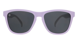 Front view of the Goodr Run With Us sunglasses against a transparent background. The eyewear features a classic, subtly squared wayfarer-style frame in a solid light lavender purple. The lenses are a solid dark grey, with a small, subtle white emblem etched into the top outer corner of the left lens.