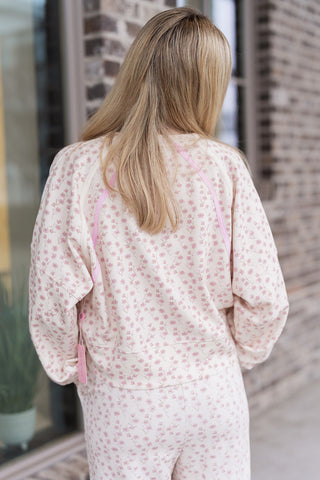 Rear view of the Petite Petal Pullover highlighting the unique pink contrast flatlock stitching along the raglan sleeves. The back view emphasizes the voluminous sleeve design and the high-quality structural seams of this lightweight spring layer.