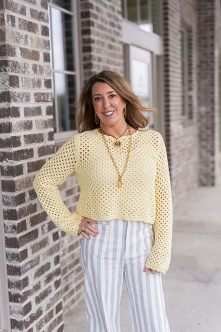 A portrait view highlighting the Lemon Sherbert Top's delicate scallop trim at the neckline and the textured crochet design. The soft pastel yellow hue is accessorized with layered gold necklaces, emphasizing the top's artisanal boutique style.