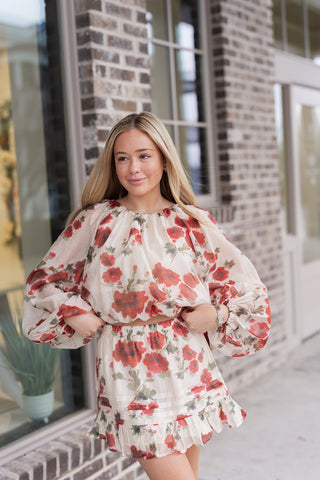 Portrait view of the Rosette Reverie Blouse highlighting the gathered round neckline and the sheer, airy texture of the floral chiffon fabric. The oversized botanical rose motif in red and pink stands out against the cream base, while the voluminous sleeves add a romantic, high-end boutique feel.
