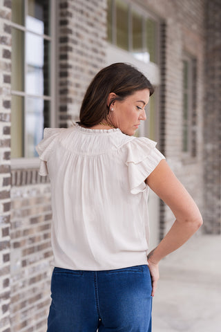 Close-up and profile views of the Rosé Ruffle Top in Champagne, highlighting the ruffled stand collar and the delicate gathering along the back yoke. The image captures the breathable, lightweight quality of the fabric and the romantic, vintage-inspired charm of the tiered sleeve architecture.