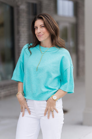 A detailed portrait view of the Seafoam Serenity Knit Top highlighting the classic ribbed crew neckline and the high-quality soft-touch texture of the fabric. The image showcases the relaxed 3/4 length wide sleeves and the polished, non-sheer appearance of the knit against a neutral boutique backdrop.