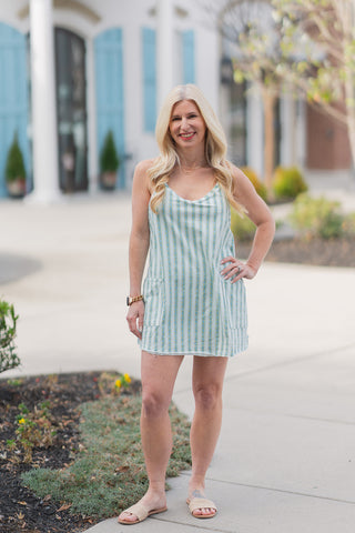 Full-length front view of the "Coastal Stripe" Pocket-Full-Of-Sunshine Romper. This hybrid piece combines a feminine floral-stripe pattern with athletic functionality, featuring prominent front pockets and a raw-edge hem for a trendy, lived-in feel.