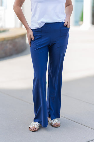 A close-up view of the Deep Sea Drift Pants highlighting the smooth, flat-front waistband and functional side pockets. The image showcases the vertical seam detailing that runs down the center of each leg, providing a structured, "pressed" appearance to the navy performance fabric. The wide-leg cut flares gently toward the hem, emphasizing a blend of professional tailoring and breezy comfort.