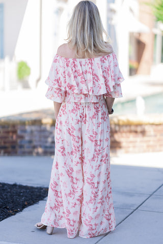 Back view of the Bellini Brunch Set showcasing the beautifully synchronized, two-piece matching ensemble. The image highlights the continuous double-layered ruffle overlay of the off-the-shoulder top and the sweeping, floor-skimming silhouette of the wide-leg trousers. The breathable, lightweight woven fabric drapes elegantly over nude block heels, illustrating the outfit's billowy movement and optimal airflow for warm summer days.