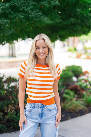 A medium portrait shot of the Creamsicle Pop Ribbed Top highlighting the structural details of the flattering wide boat neckline and short raglan-style sleeves. The close-up emphasizes the high-quality, breathable knit fabric and the clear interplay between the vertical ribbing and bold horizontal stripes, finished beautifully with heavy-duty ribbed trim along the collar and cuffs.