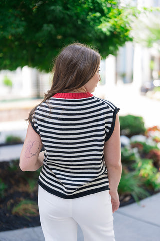 Back view of the Midnight in Paris Sweater Vest showcasing the clean, unlined drape of the lightweight sweater knit fabric. The continuous black and cream horizontal stripes line up cleanly across the back, framed by the pops of the crimson red collar and solid black ribbed bottom hemline.