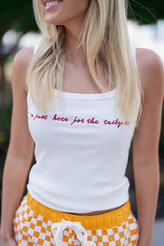 A close-up portrait shot of the Stadium Social Tank focusing on the chest area. The image highlights the clean, raised texture of the cursive embroidery that reads "I'm just here for the tailgate" in a rich crimson red thread. The detailed view showcases the fine vertical ribbing of the soft cotton-blend fabric and the clean trim of the square neckline.