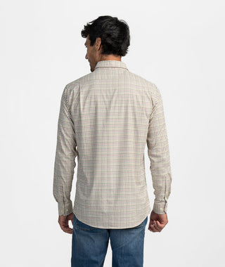 Back view of a man wearing a Men's Stretch Micro-Check Button-Down Shirt in a tan, red, and blue checkered pattern, paired with dark blue jeans. This long-sleeve, casual button-down is tailored with a back yoke and subtle pleating for a comfortable, smart-casual fit. The model is shown from the waist up against a neutral light gray background, highlighting the shirt's relaxed yet structured hang and natural movement.