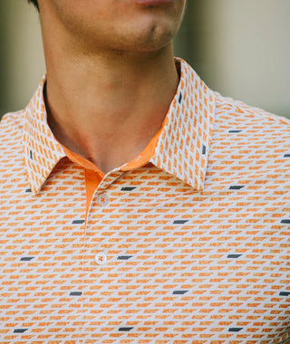 A detailed close-up shot of the Touchdown In Tennessee Polo showcasing the structured collar and two-button placket lined with solid vibrant orange trim. Highlights the technical moisture-wicking fabric texture and the repeating micro-pattern of orange and dark navy Tennessee state outlines.
